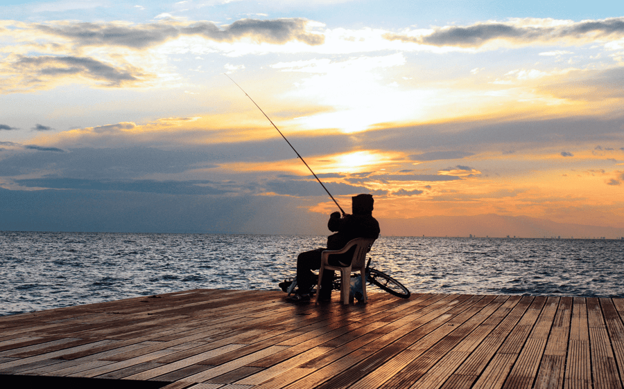 Man sitting on jetty fishing - Advanced Phishing Attacks