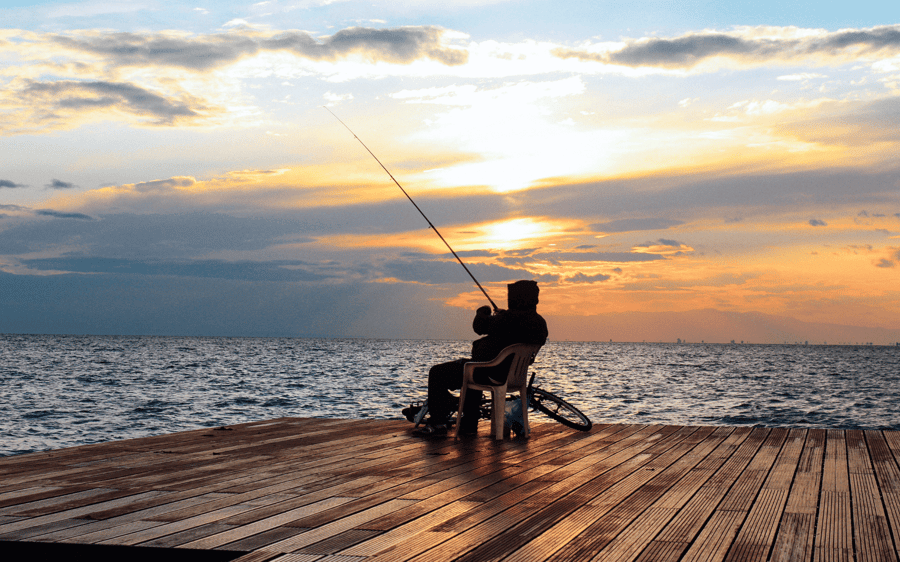 Man sitting on jetty fishing - Advanced Phishing Attacks